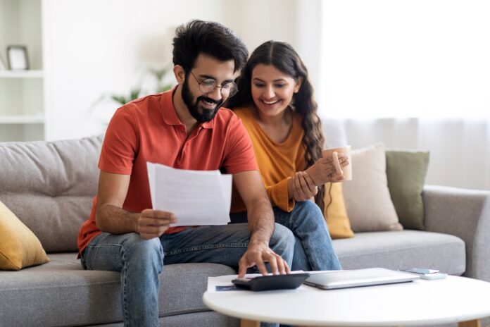 Happy,Indian,Spouses,Checking,Financial,Documents,And,Calculating,Family,Budget